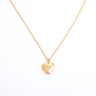 Gold heart-shaped necklace with a small diamond on a white background
