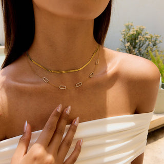 Woman wearing a gold necklace with a blurred background