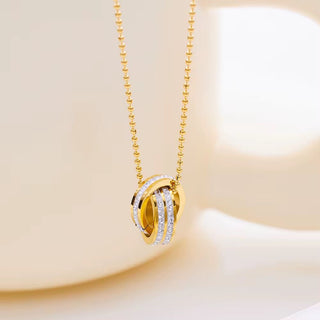 Gold necklace with a circular pendant on a soft beige background