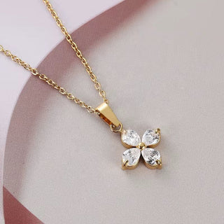 Gold necklace with a butterfly-shaped pendant on a light pink background