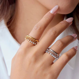 Close-up of a hand wearing two decorative rings with a blurred background