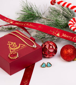 Jewelry set with a red box, gold necklace, and earrings on a Christmas-themed background.
