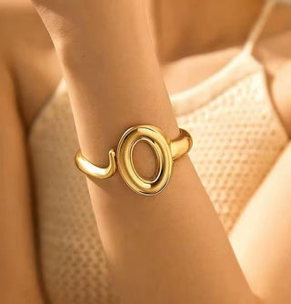 Gold ring on a person's wrist with a soft focus background