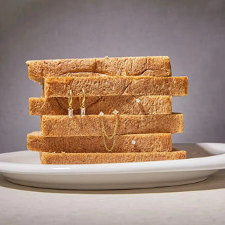 Stack of toast with jewelry on a gray background
