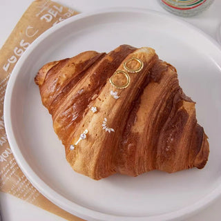 Croissant with decorative elements on a white plate