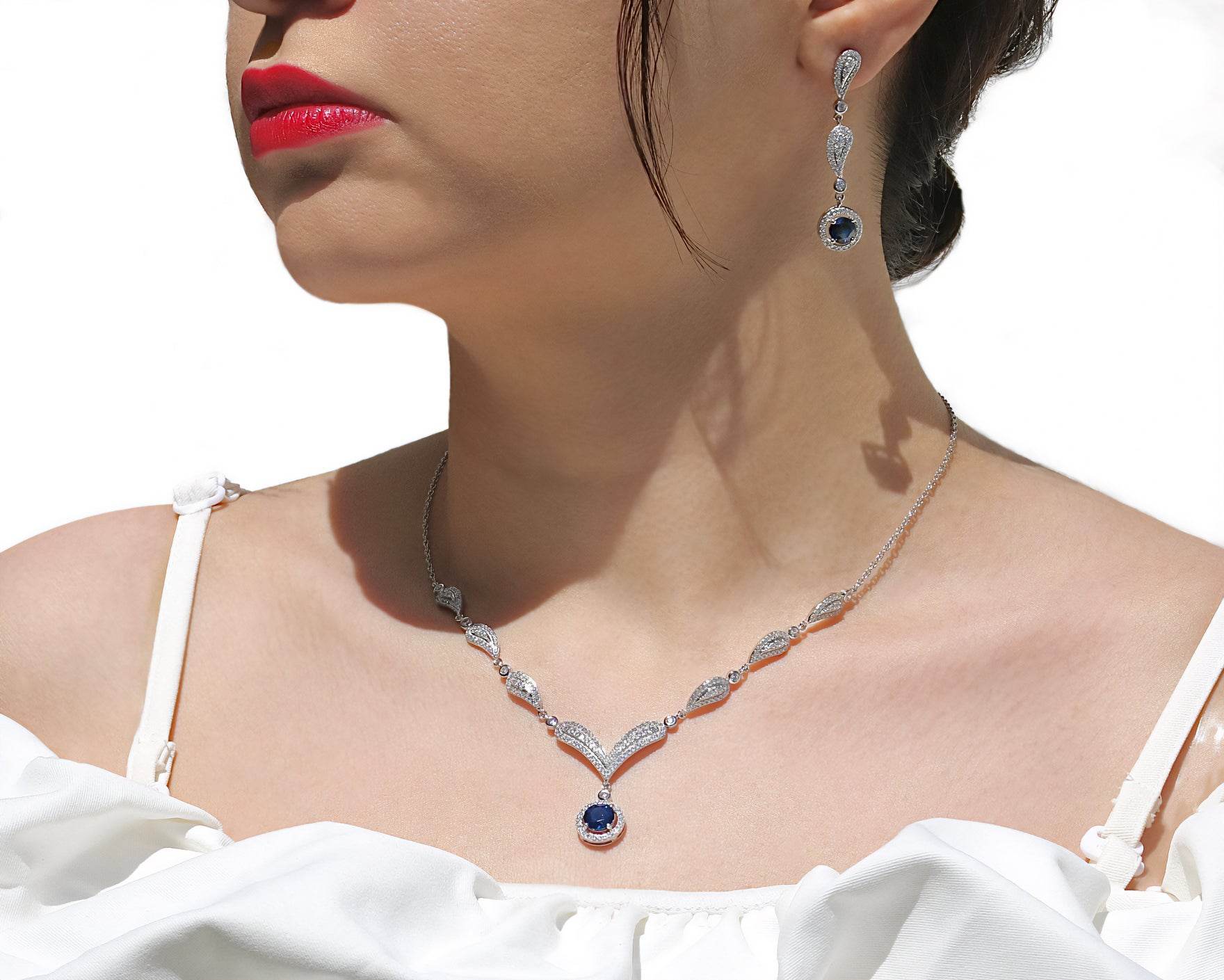 Elegant women’s drop earrings in rhodium silver with blue gemstone centerpiece