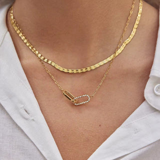 Gold necklaces on a person wearing a white shirt