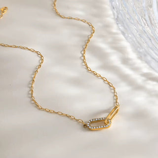Gold necklace with a decorative clasp on a light background