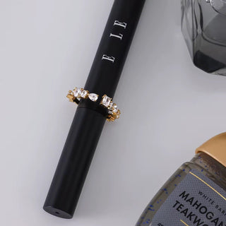 Black eyeliner pencil with decorative elements on a light gray background