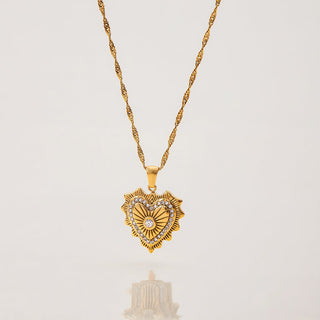 Gold heart-shaped pendant necklace on a light gray background
