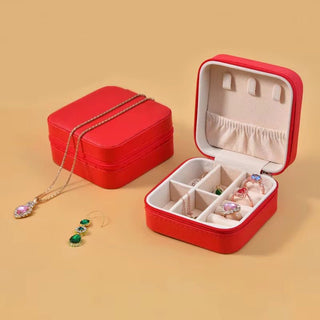 Red jewelry box with jewelry on a beige background