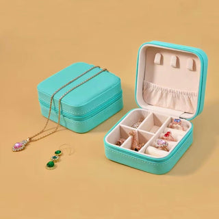 Turquoise jewelry box with jewelry on a beige background