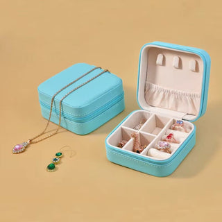 Turquoise jewelry box with jewelry on a beige background