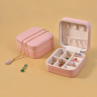 Pink jewelry box with jewelry on a beige background