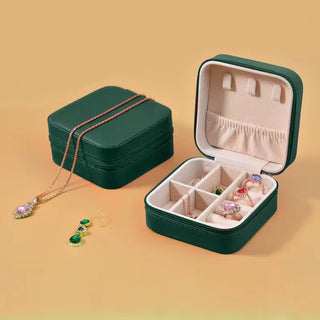 Green jewelry box with jewelry on a beige background