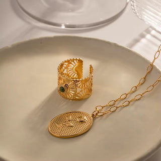 Gold ring and necklace on a white plate
