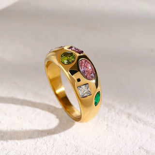 Gold ring with multicolored gemstones on a white background